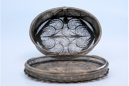 Guarda joias em prata de filigrana de forma oval e assente sobre quatro pés com tampa basculante.